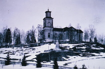 Kirkon mäki edustallaan vuonna 1938 pystytetty kansalaissodan muistomerkki. Huomaa hautausmaata reunustavat kuuset, jotka nykyisin ovat jo kypsässä iässä.