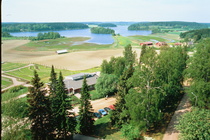 Toinen suunta tornista. Edessä näkyy seurakuntatalo ja taustalla Kirkkojärvi. Hautausmaan laajennuskin on jo valmis.